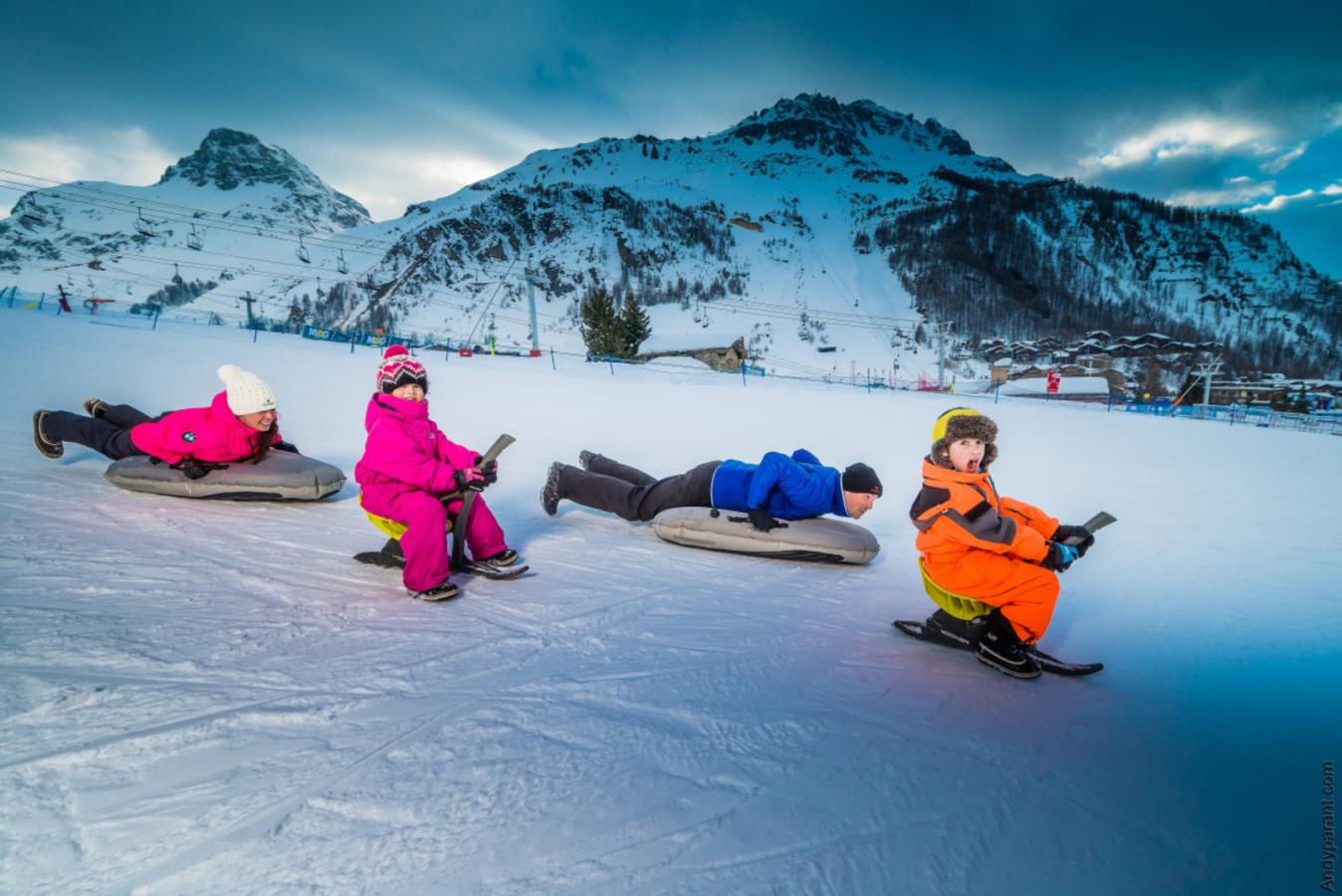 Family of four tobogganing in val d'isere