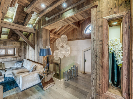 Open-plan living room with vaulted ceilings and central fireplace – Carat – Courchevel 1850 1