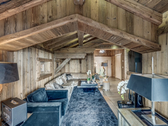 Open-plan living room with vaulted ceilings and central fireplace – Carat – Courchevel 1850 2